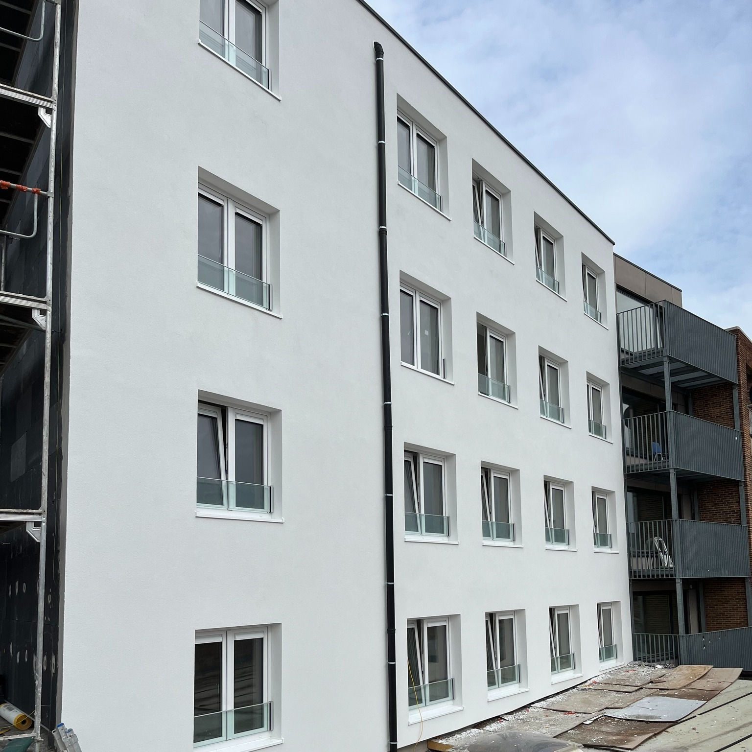 Appartementsgebouw met nieuwe gevelisolatie en witte sierpleister