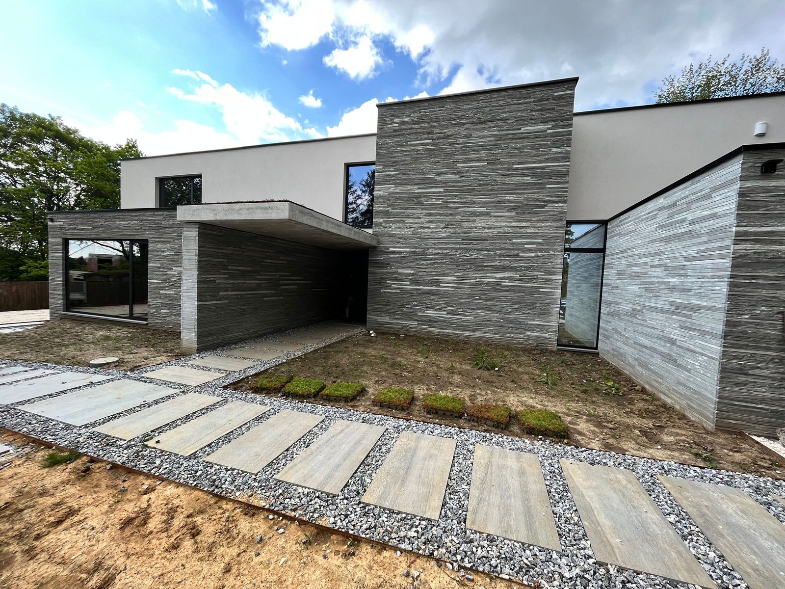 Moderne woning met grijze steenstrips op gevelisolatie