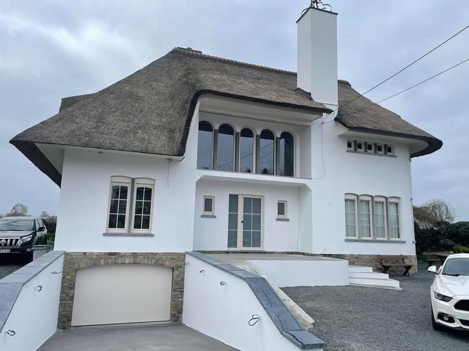 Gerenoveerde villa met rieten dak en witte gevelbepleistering