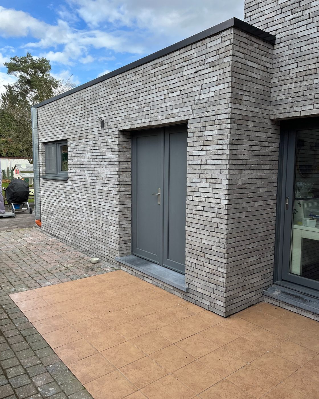 Moderne woning bekleed met lichtgrijze steenstrips op isolatie