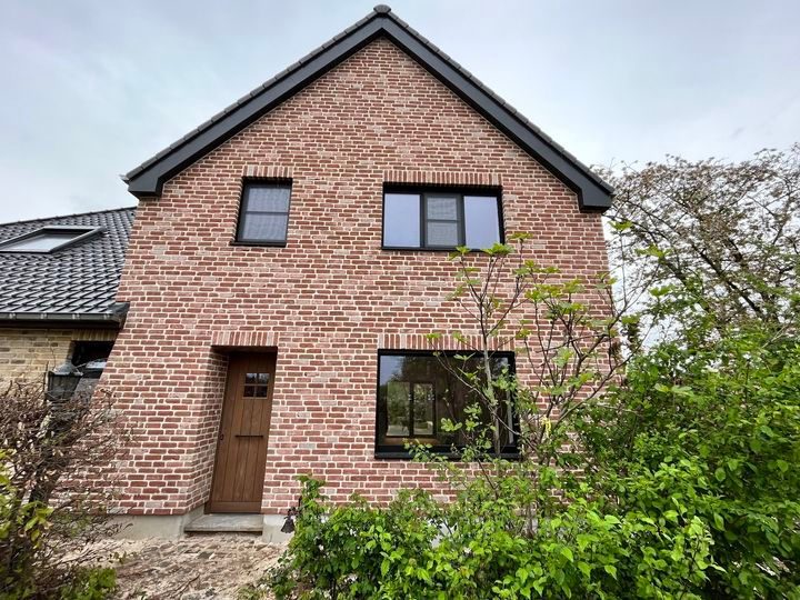 Woning met roodbruine steenstrips op na-isolatie