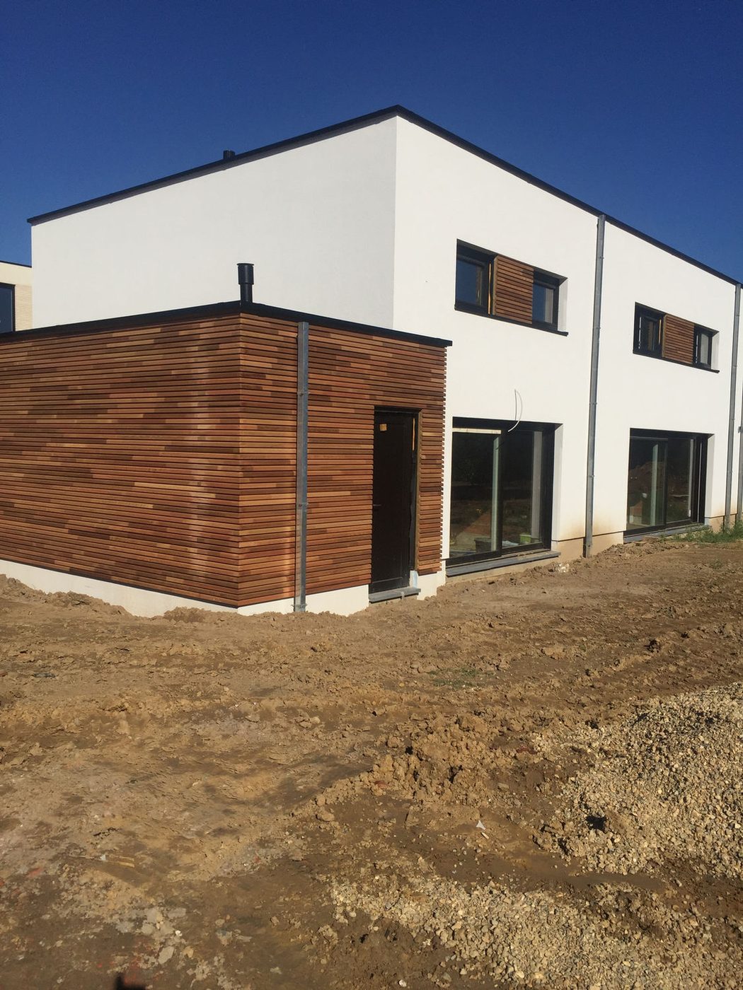 Nieuwbouwvolume met witte crepi en verticale houten gevelbekleding