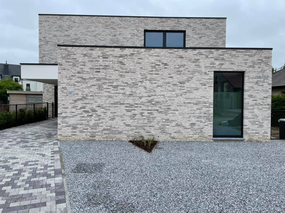 Moderne woning bekleed met witte steenstrips op isolatie