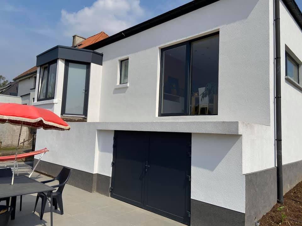 Dezelfde hoekwoning na gevelisolatie en witte gevelbepleistering